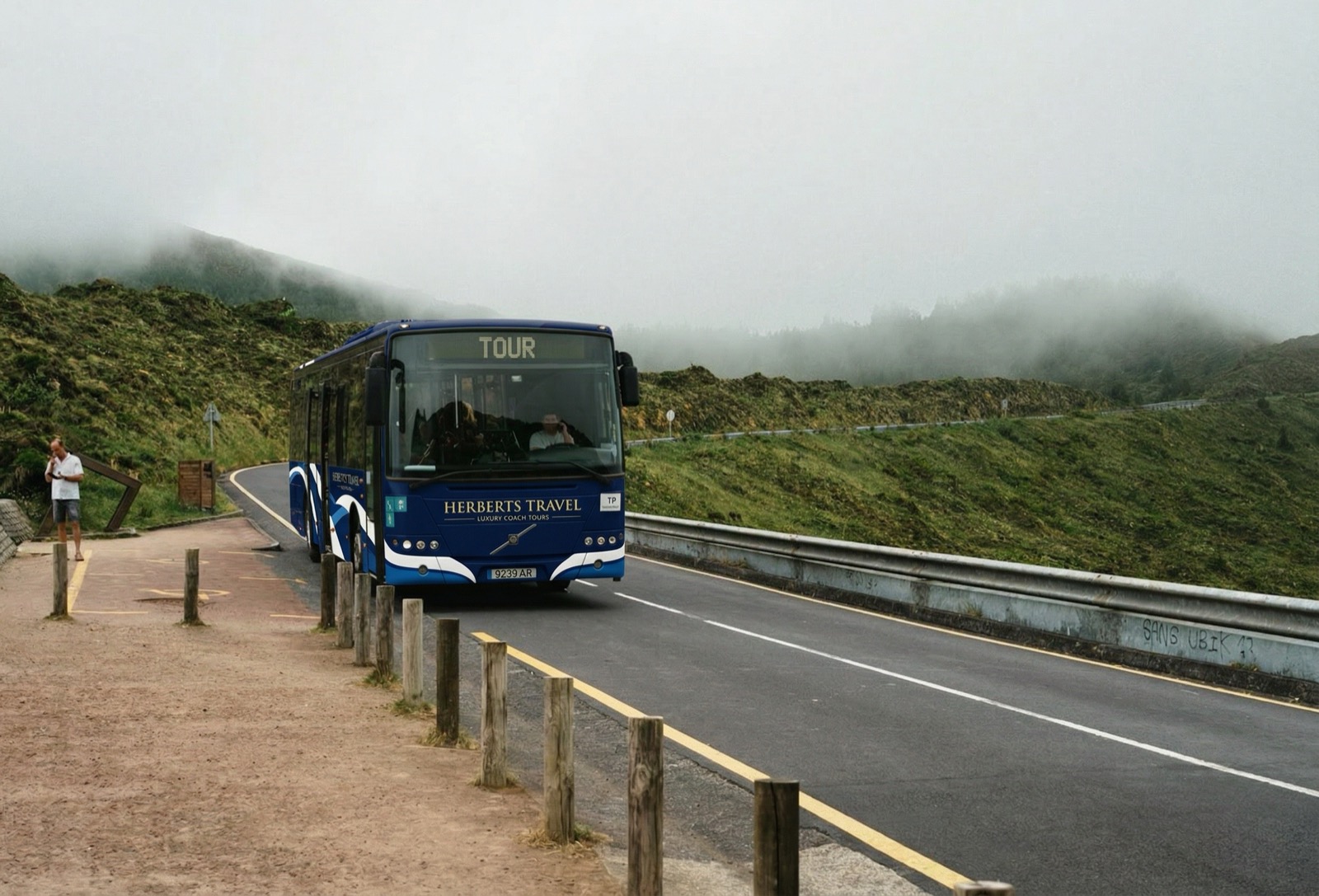 A Herberts Travel touring coach on a hillside road